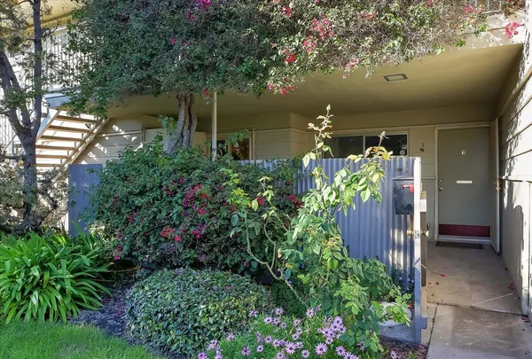 a vase of flowers sitting in front of yellow house