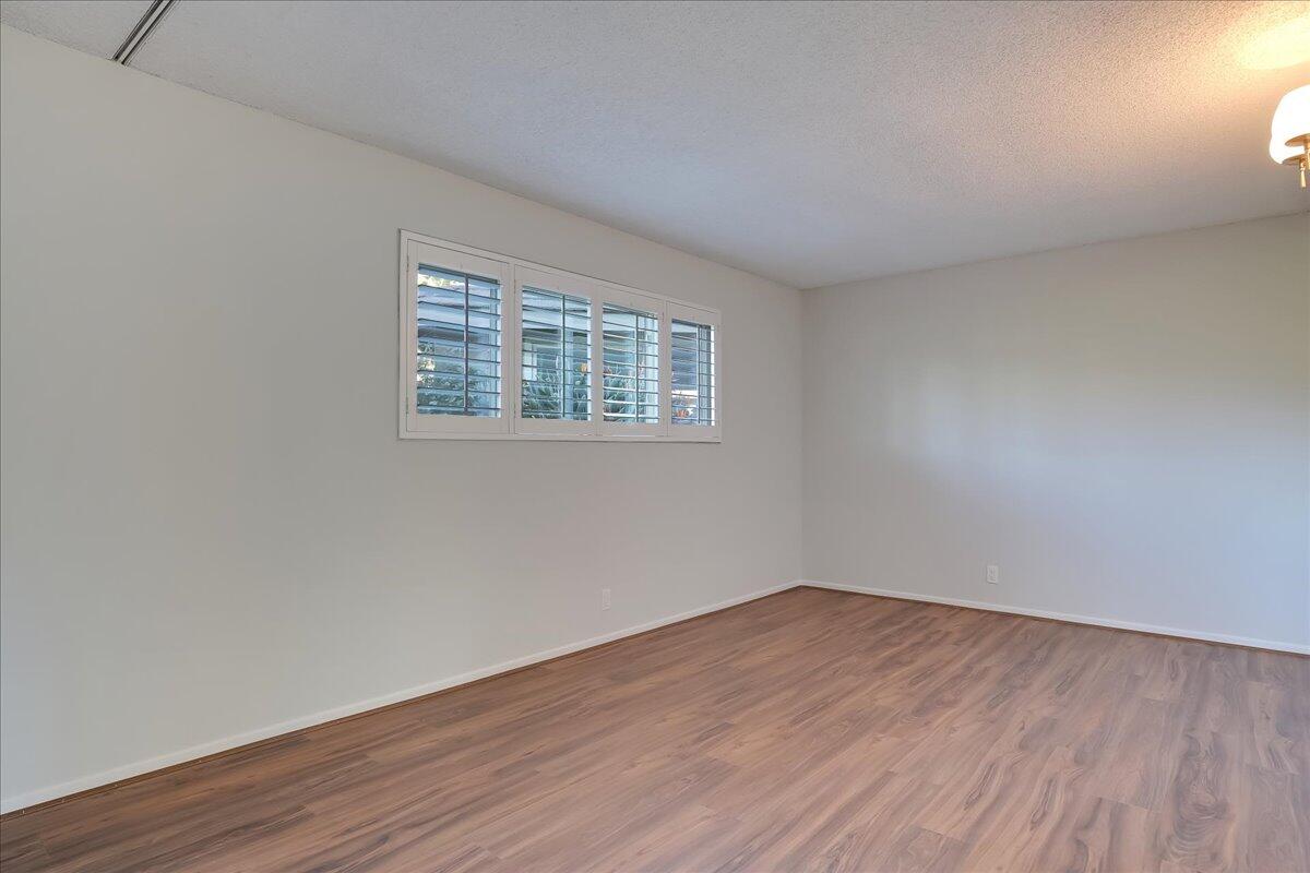 5910 Encina Road, Unit 3 Goleta, CA 93117 - Photo 20 of 45 a view of an empty room with wooden floor and a window