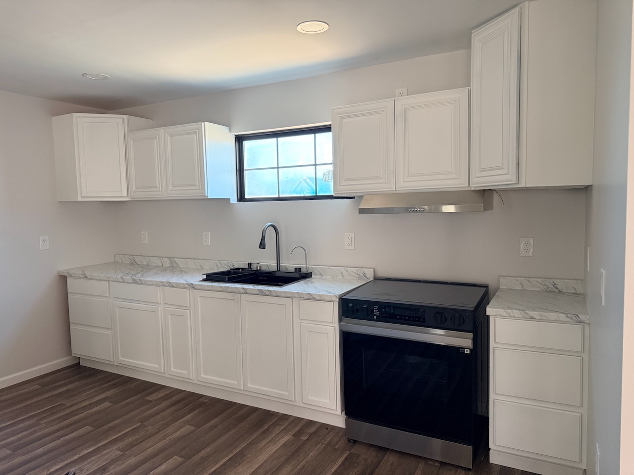 3512 Castor Street Houston, TX 77022 - Photo 14 of 24 a kitchen with stainless steel appliances granite countertop a stove a sink and white cabinets