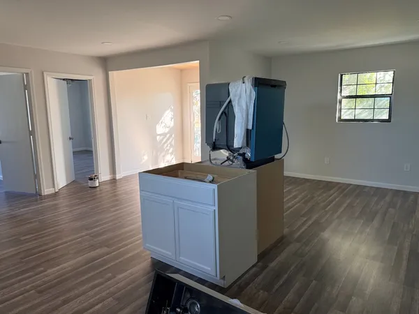 a kitchen with stainless steel appliances a refrigerator and a wooden floor