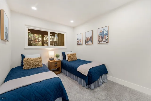 a bedroom with two beds and painting on the wall