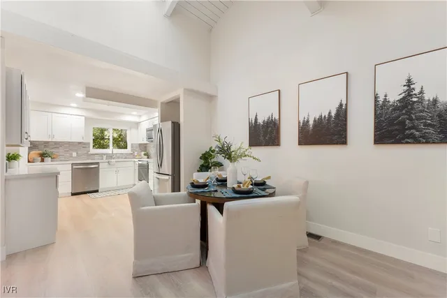 a room with white cabinets and chandelier