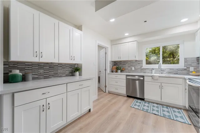 a kitchen with granite countertop white cabinets and white appliances