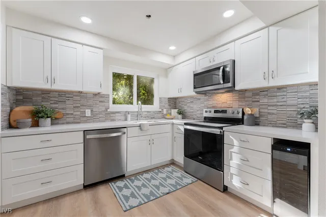 a kitchen with granite countertop cabinets stainless steel appliances and a window