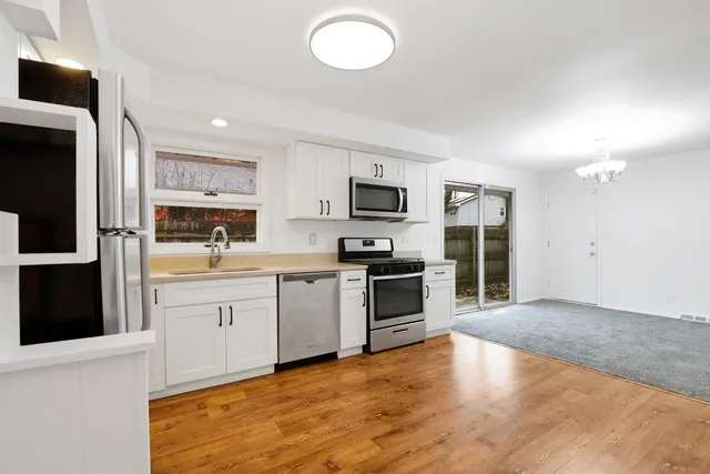 a kitchen with granite countertop a refrigerator stove top oven and sink