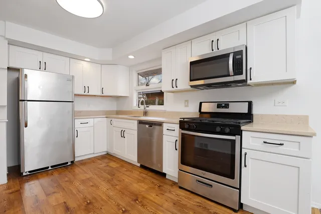 a kitchen with white cabinets and stainless steel appliances