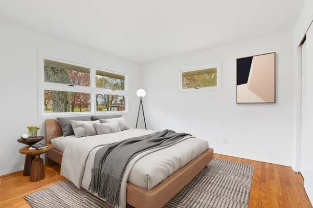 a bedroom with a bed and wooden floor