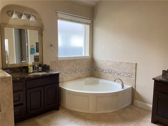 an empty room with wooden floor and a bathroom