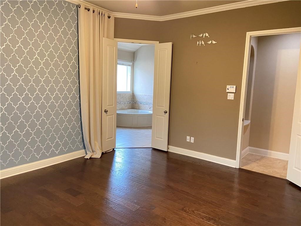 3216 Herradura Drive Cedar Park, TX 78641 - Photo 23 of 35 an empty room with wooden floor and a bathroom