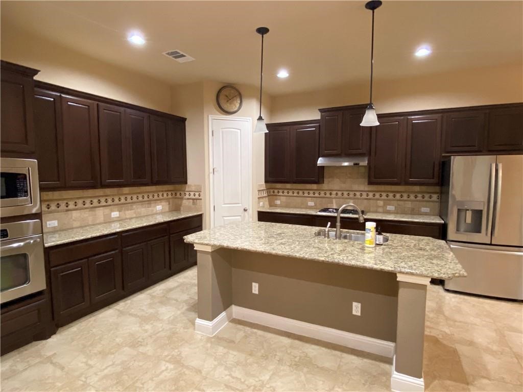 3216 Herradura Drive Cedar Park, TX 78641 - Photo 6 of 35 a kitchen with a sink a counter space appliances and cabinets