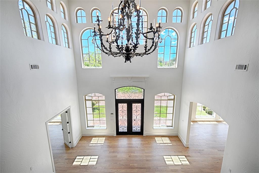 Foyer with a high ceiling, a healthy amount of sunlight, and visible vents