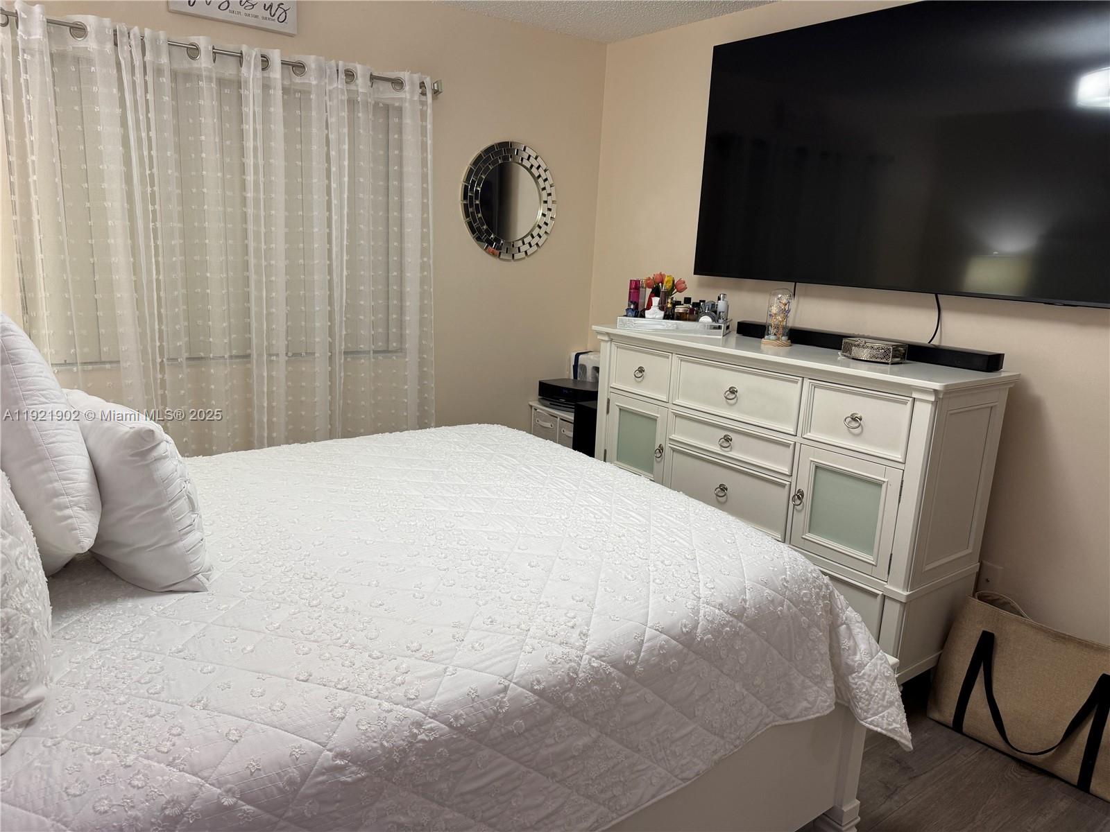 9446 Southwest 140th Court, Unit 9446 Miami, FL 33186 - Photo 12 of 48 a bedroom with a bed and a flat tv screen on dresser