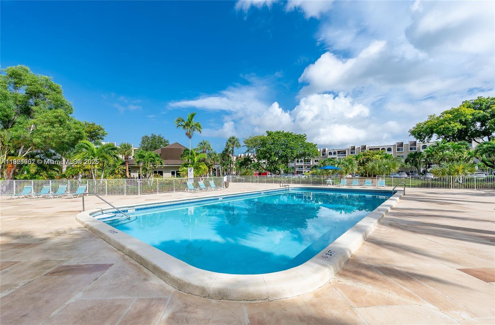 9446 Southwest 140th Court, Unit 9446 Miami, FL 33186 - Photo 31 of 48 a view of a swimming pool with outdoor seating and plants
