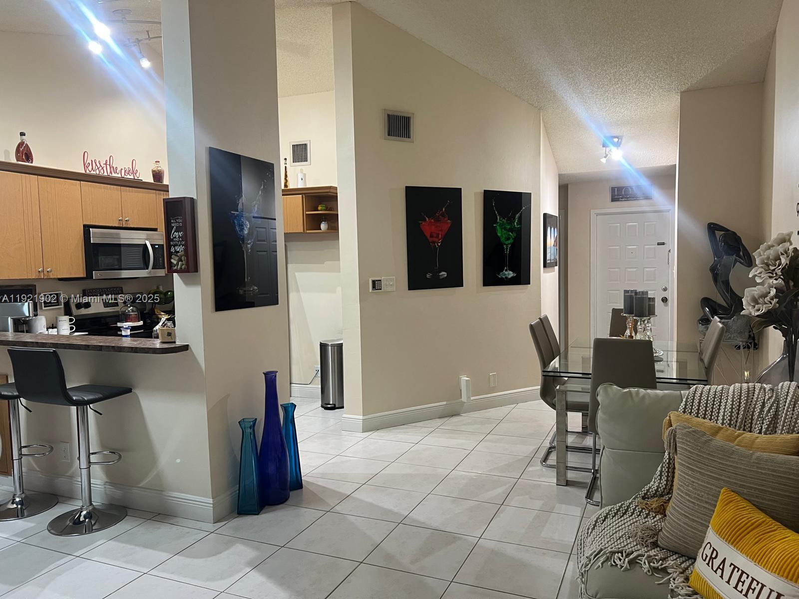 9446 Southwest 140th Court, Unit 9446 Miami, FL 33186 - Photo 33 of 48 a kitchen with stainless steel appliances kitchen island granite countertop a refrigerator and a stove