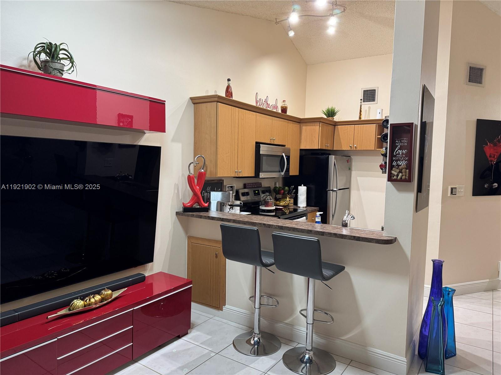 9446 Southwest 140th Court, Unit 9446 Miami, FL 33186 - Photo 39 of 48 a kitchen with stainless steel appliances kitchen island granite countertop a table and chairs in it