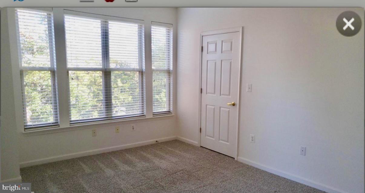 1855 Stratford Park Place, Unit 214 Reston, VA 20190 - Photo 11 of 29 an empty room with windows