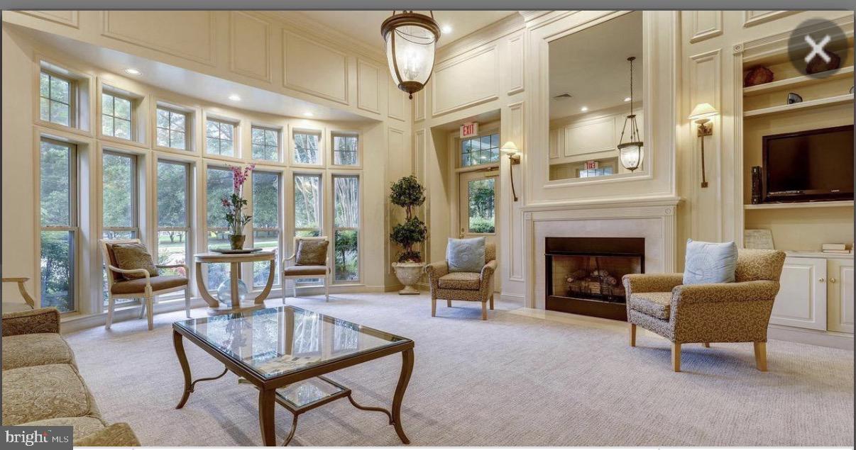 1855 Stratford Park Place, Unit 214 Reston, VA 20190 - Photo 3 of 29 a living room with furniture a fireplace and a flat screen tv