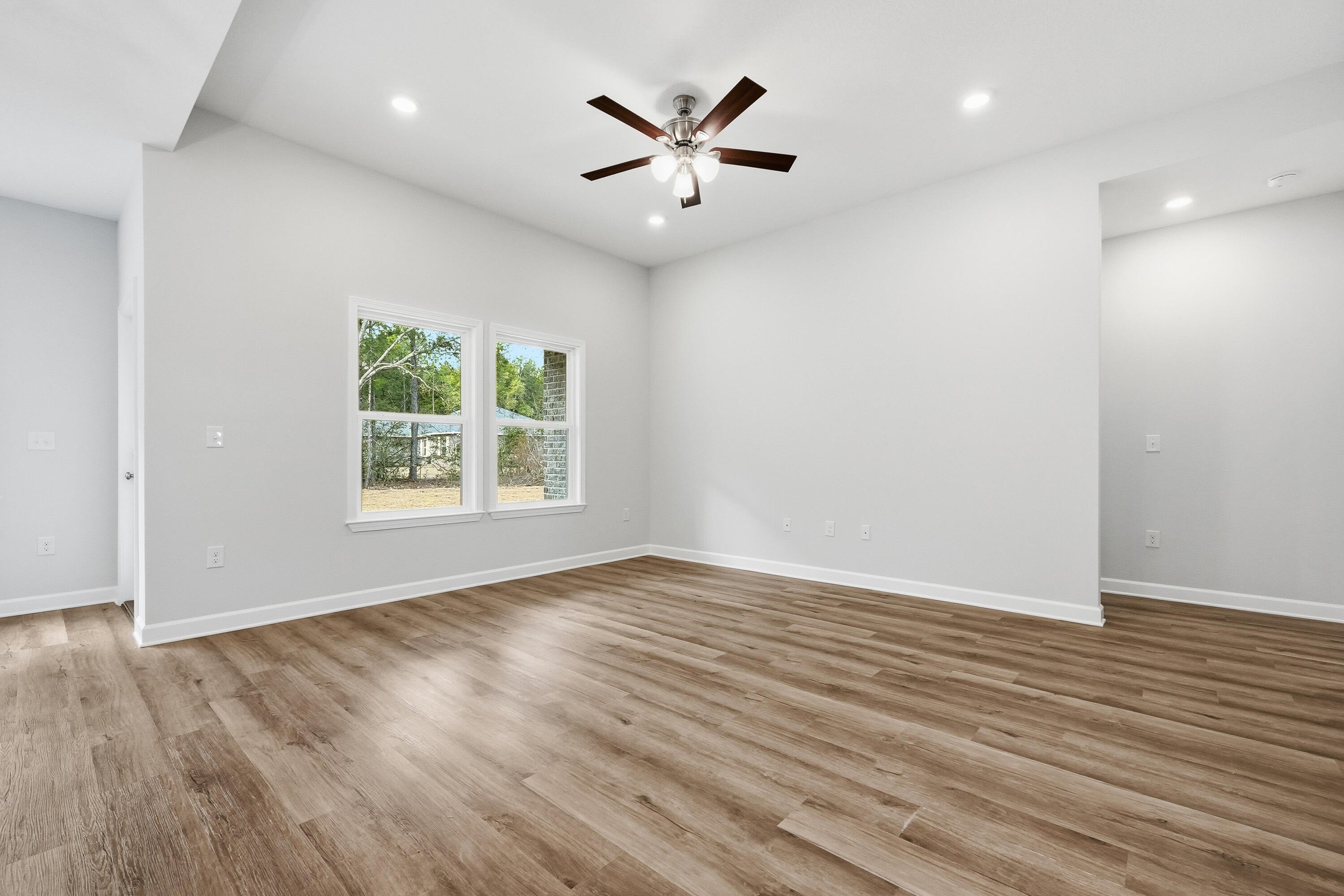 6108 Mildred's Way Crestview, FL 32539 - Photo 8 of 27 an empty room with wooden floor and windows