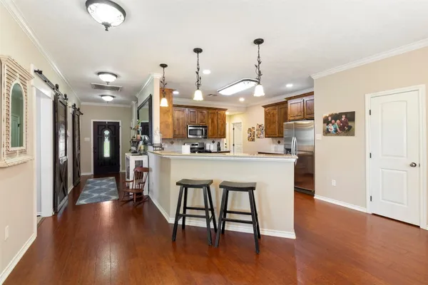 a kitchen with stainless steel appliances granite countertop a refrigerator a stove and a wooden floors