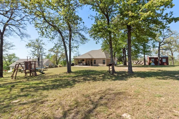 a front view of a house with a yard and trees
