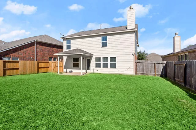 a view of a backyard with wooden fence