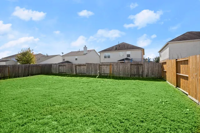 a view of a backyard with wooden fence