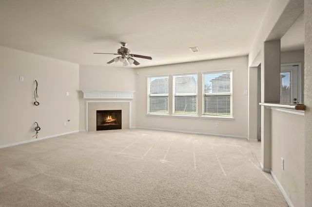 a view of an empty room with a fireplace and a window