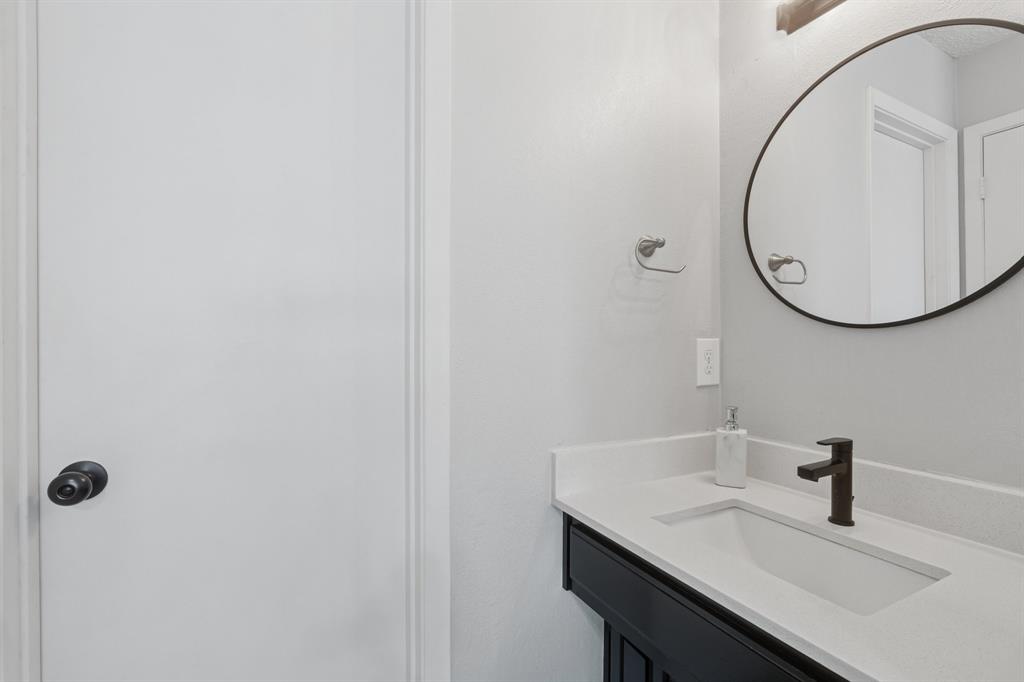 9780 Windy Ridge Road Frisco, TX 75033 - Photo 13 of 25 Bathroom vanity featuring a rectangular undermount sink, a dark bronze faucet, and a light-colored countertop