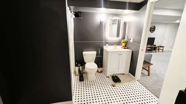 a bathroom with a sink a toilet a mirror and shower