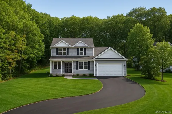 a front view of a house with a garden and trees
