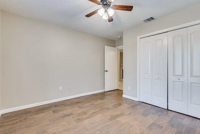 a view of an empty room and chandelier fan