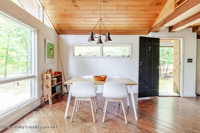 a dining room with wooden floor a chandelier a wooden table and chairs