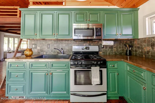 a kitchen with granite countertop a stove top oven microwave and cabinets