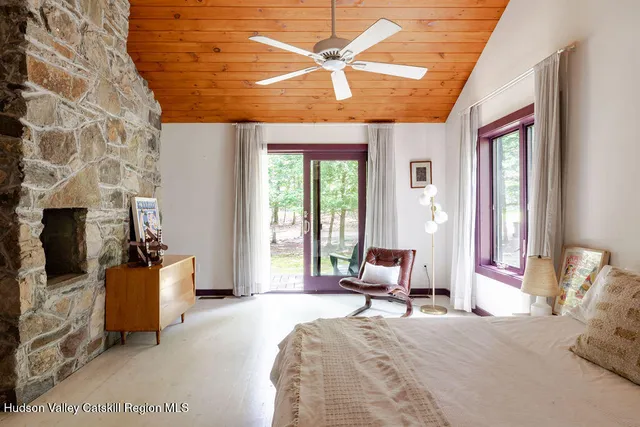 a bedroom with a bed a large window and furniture