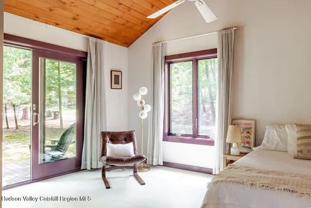 a bedroom with a bed and large window