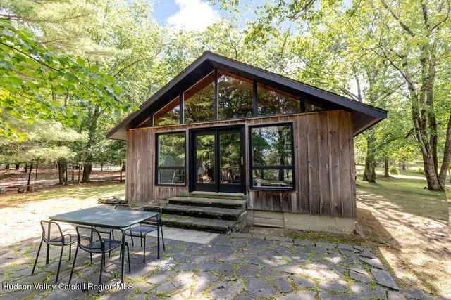 a view of a chair and table in backyard of the house