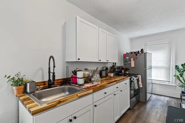 a kitchen with stainless steel appliances granite countertop a sink refrigerator and cabinets