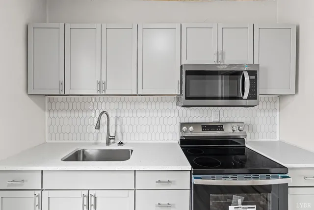 a kitchen with granite countertop white cabinets stainless steel appliances and a sink