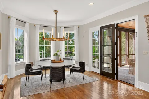 a kitchen with stainless steel appliances granite countertop a stove a sink a oven a refrigerator a stove and white cabinets with wooden floor