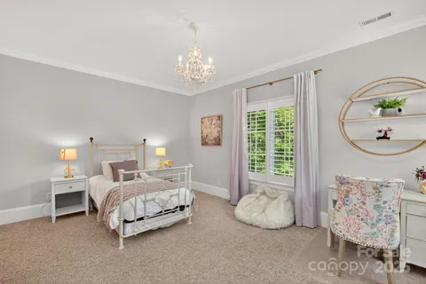 a bedroom with furniture and a large window