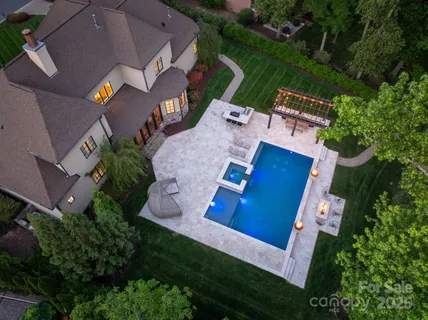an aerial view of a house with swimming pool a yard and outdoor seating