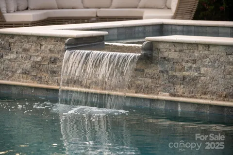 a view of swimming pool with chairs and garden