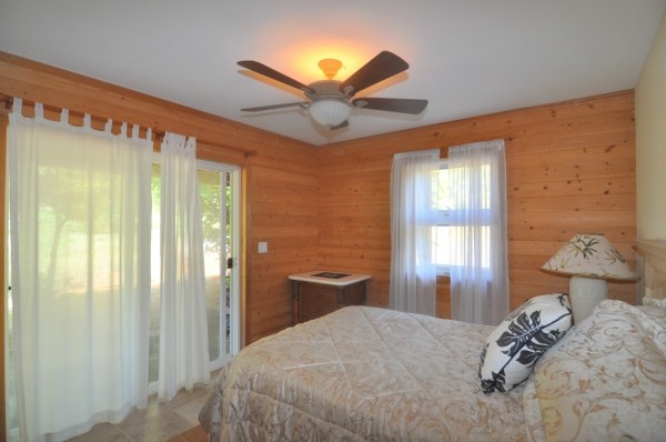 7158 Kahuna Road, Unit 1 & 2 Kapaa, HI 96746 - Photo 13 of 23 a bedroom with a bed and a chandelier