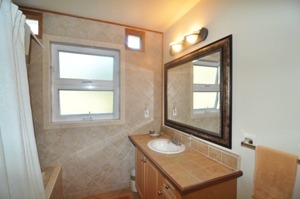 7158 Kahuna Road, Unit 1 & 2 Kapaa, HI 96746 - Photo 16 of 23 a bathroom with a sink a mirror and a window