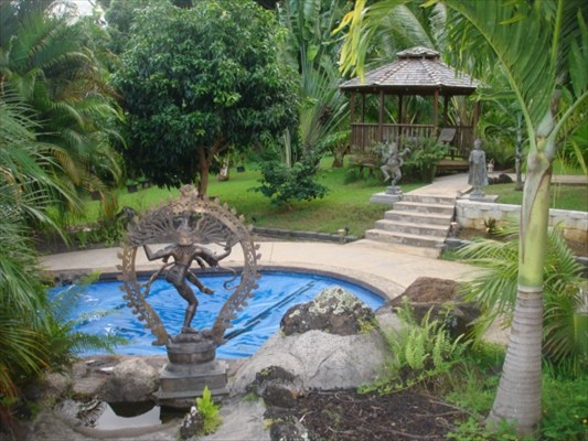 7158 Kahuna Road, Unit 1 & 2 Kapaa, HI 96746 - Photo 21 of 23 a view of backyard with a table and chairs under an umbrella