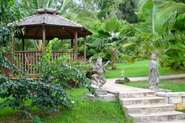 7158 Kahuna Road, Unit 1 & 2 Kapaa, HI 96746 - Photo 22 of 23 a view of a garden with a bench and trees