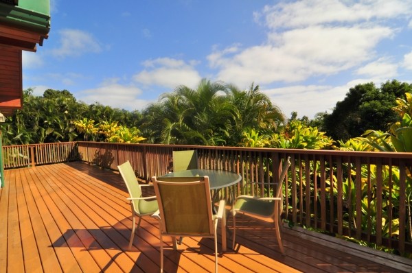 7158 Kahuna Road, Unit 1 & 2 Kapaa, HI 96746 - Photo 3 of 23 a view of a balcony with wooden floor and outdoor seating