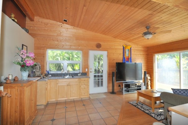 7158 Kahuna Road, Unit 1 & 2 Kapaa, HI 96746 - Photo 8 of 23 a living room with furniture a flat screen tv and a floor to ceiling window
