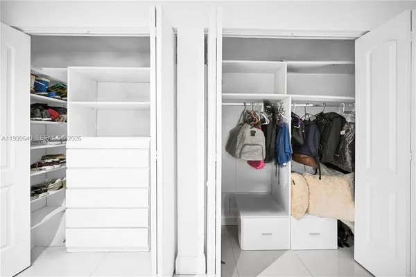 a view of walk in closet with clothes and shoes