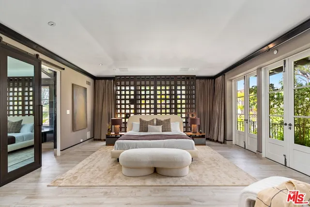 a spacious bedroom with a bed a television and a large window